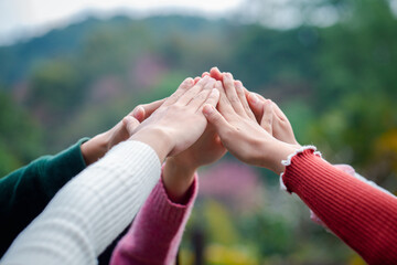 A diverse group of people connects their hands as a supportive sign expressing a sense of teamwork....