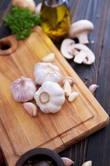 Garlic on wooden chopping board on wooden background or table