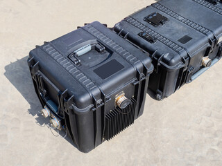 Protective cases for equipment. Shockproof cases of different sizes. Black shockproof cases on ground. Containers for transportation of expensive equipment. Shockproof containers with handles