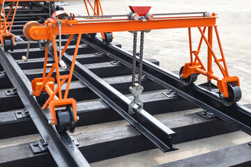 Railway construction. Manual gantry crane. Overhead crane with suspended rails. Railway repair equipment. Process of replacing railroad tracks. Overhead crane is orange. Railway equipment