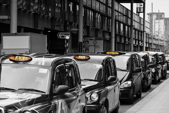 Traditional London black cabs queueing at a taxi rank outside Kings Cross Station.