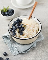 Rice milk porridge with blueberries in a bowl close-up. The concept of a healthy and tasty breakfast.