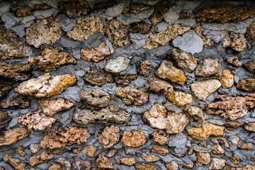 Old style wall made of rough stones with cement. Ancient grunge stones wall backdrop. Background of old vintage wall.Ancient style stone fence decoration to be beautiful and strong with natural stone.