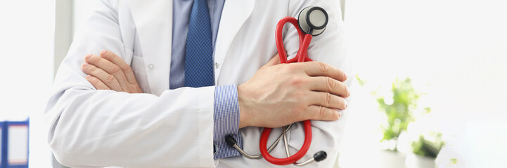 Male doctor in a white coat with a stethoscope in his hands