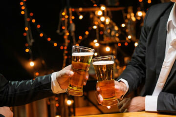 food and drink male friends are happy drinking beer and clinking glasses at a bar or pub.