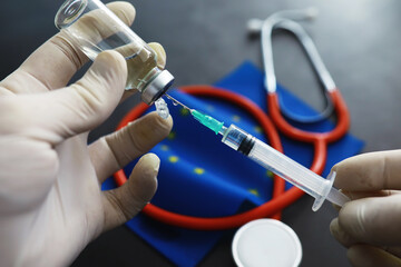 Health care concept. EU flag and stethoscope on a gray background. Vaccination and epidemic.