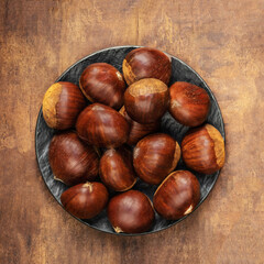 Chestnuts on an old ructic background. Autumn Horse chestnuts top view, copyspace.