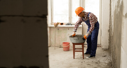 builder mixing mortar to install bricks block on construction site, repair house concept.