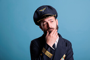 Pensive thoughtful airline capitan in uniform questioning, making decision, thinking, making...