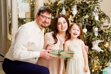 happy family with box of gift by Christmas tree. tradition giving gifts