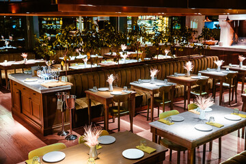 Interior of a cozy modern restaurant with living plants in the hall