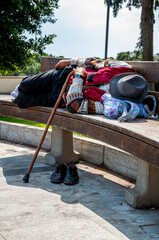 Uomo senzatetto dorme sulla panchina