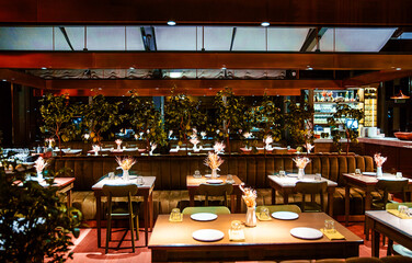 Interior of a cozy modern restaurant with living plants in the hall