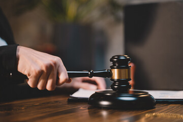 The gavel blow of a judge or decision-maker to authority about business, justice, or the law for a court proceeding. A picture of a hand hitting a hammer for finalizing the decision in courtroom.