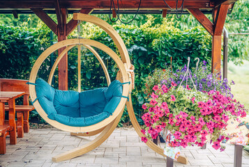 wooden swing in a garden full of blooming flowers
