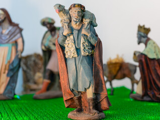 Close up of a shepherd Christmas figure carrying a sheep on his back
