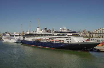 Classic Holland America HAL and Oceania cruise ship or cruiseship liner in port of Montevideo, Uruguay during South America cruising in summer with blue sky and containers and cargo