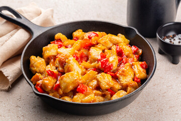 Close-up of iron pan skillet with turkey curry cooked with bell peppers and pineapple.
