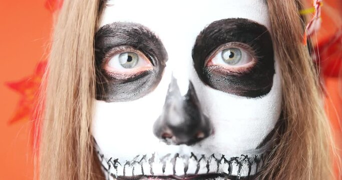 Make-up for Halloween, sugar Mexican skull, make-up. The girl beckons to herself. Slow motion.