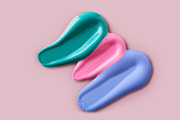 Samples of colorful eye shadows on pink background. Swatch smears of cream makeup