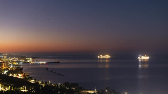 Timelapse of night landscape of cruise ships and pier with sky full of stars.