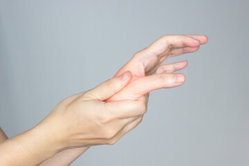 Women is rubbing hand and thumb with pain syndrome and feel numb