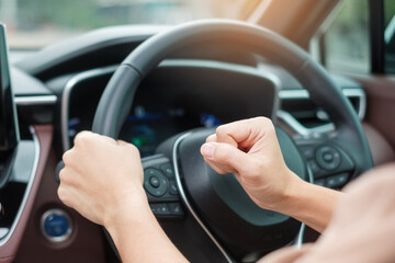 Fototapeta na wymiar woman driver honking a car during driving on traffic road, hand controlling steering wheel in vehicle. Journey, trip and safety Transportation concepts