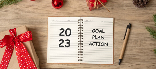 2023 Goal Plan Action with notebook, Christmas gift and pen on wood table. Xmas, Happy New Year, Resolution, To do list, start and Strategy concept