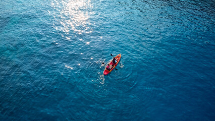 Aerial drone photo of colourful sport canoes as shot from above in turquoise clear sea. High...