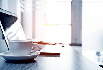 Laptop with coffee cup in office