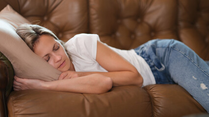 Woman sleeps in living room taking break for short nap in middle of day