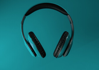 Turquoise headphones a colored background. Music concept with copyspace. Blue headphones isolated
