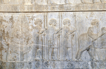 Ancient wall with bas-relief with assyrian warriors with spears, Persepolis, Iran
