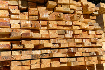 Blocks of pine sawn timber for the construction of roof houses and cottages stacked on the lumberyards site, ready for sale