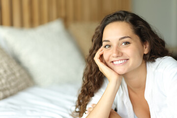 Woman with perfect smile posing on a bed