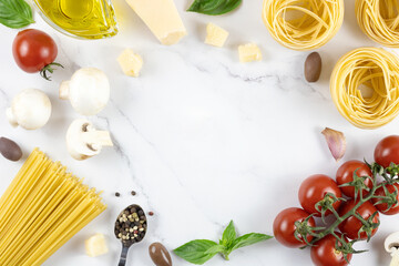 Frame of ingredients for cooking pasta on a white background, top view. Tagliatelle, tomatoes, parmesan cheese.