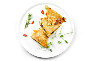 Quesadilla with cheese and vegetables in a white plate. Close-up, selective focus. White background.