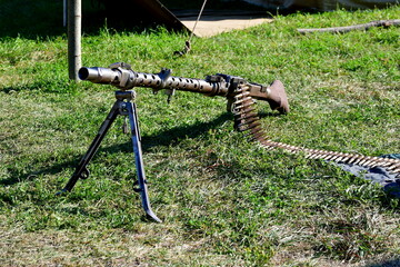 A close up on a replica of an old WWII machine gun attached to a metal frame or stand and with a...