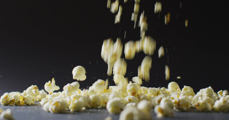 Image of close up of popcorn falling on black background