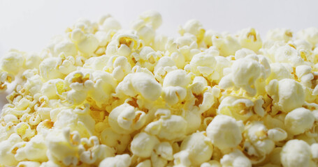 Image of close up of popcorn falling on white background