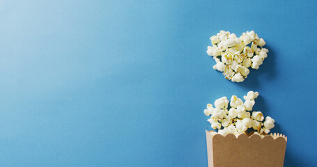 Image of close up of box of popcorn on blue background