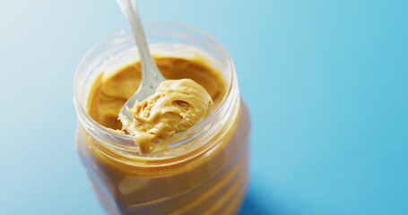 Image of close up of peanut butter on blue background