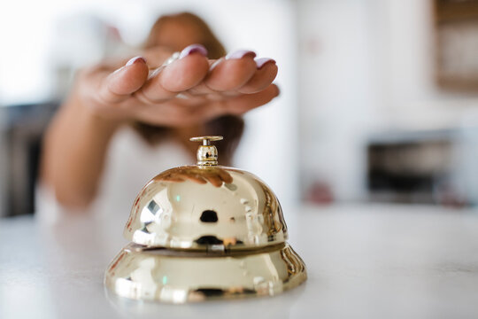 Hand of businesswoman ringing service bell at restaurant