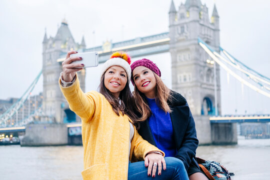 London, United Kingdom, Girlfriends taking selfie in front of Tower Bridge
