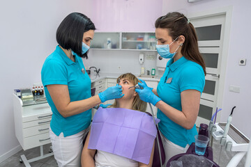 Obraz premium Dentist woman talking to her patient about the treatment of her teeth.