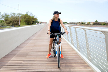 Active senior woman riding bicycle on promenade