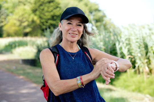 Smiling woman checking fitness tracker