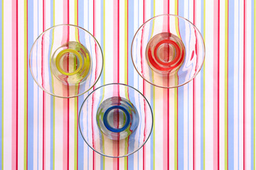 Red, yellow and blue bowls on a striped pattern