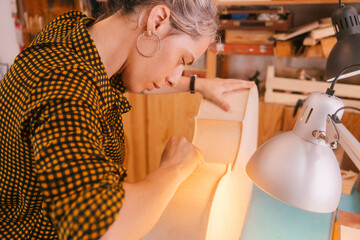 Luthier making double bass musical instrument at workshop