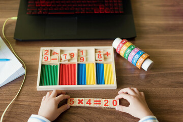 Hand's of boy arranging number blocks at home